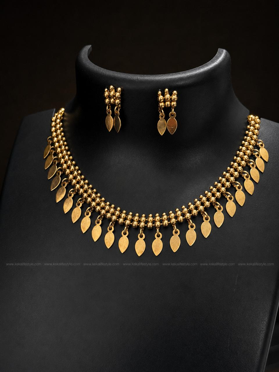 NGN0244 - Premium handcrafted Ilakkathali necklace featuring triple bead strands and elegant leaf-shaped danglings. Includes matching earrings